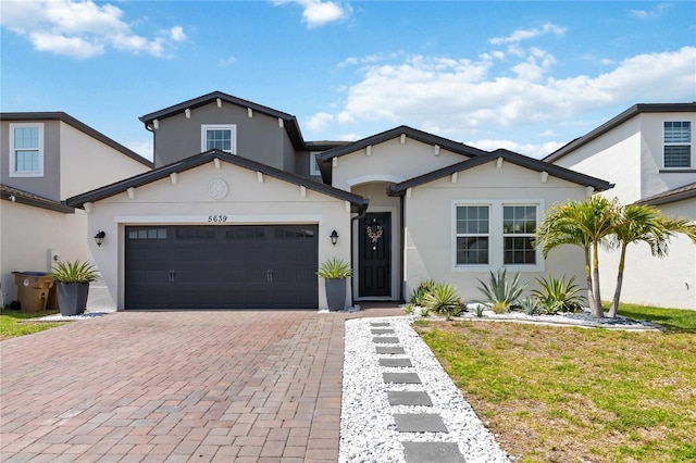 5639 Timber Meadow Way, Saint Cloud, FL 34771 - view of front of home featuring stucco siding, decorative driveway, a garage, and a front yard