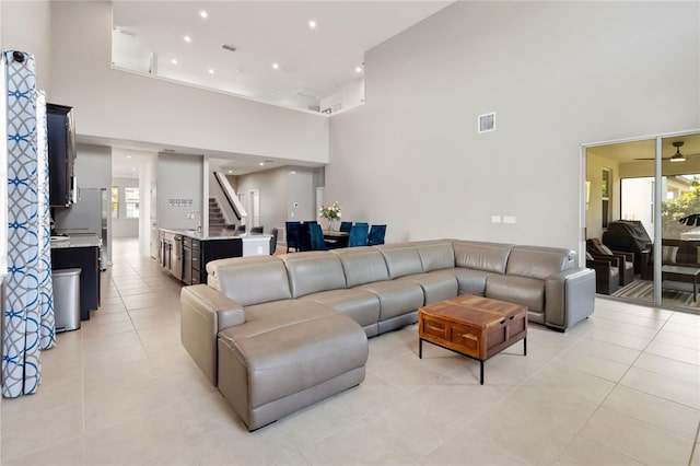 5639 Timber Meadow Way, Saint Cloud, FL 34771 - living room featuring a towering ceiling, plenty of natural light, light tile patterned flooring, and stairs