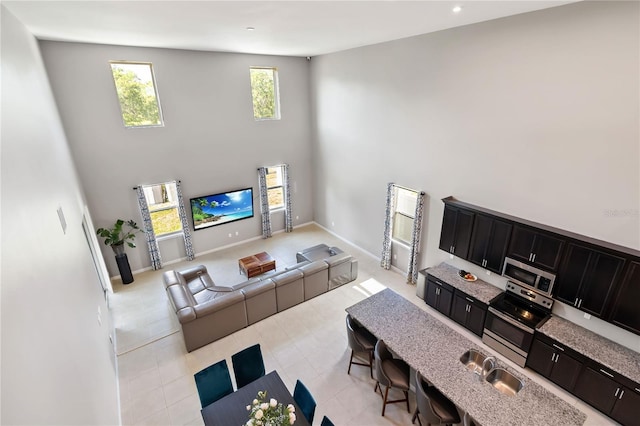 5639 Timber Meadow Way, Saint Cloud, FL 34771 - living area featuring light tile patterned floors, a high ceiling, and recessed lighting