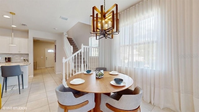 8900 Sydney Ave, Kissimmee, FL 34747 - dining area featuring stairs, a chandelier, and light tile patterned flooring