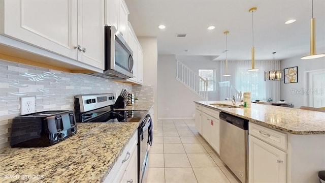 8900 Sydney Ave, Kissimmee, FL 34747 - kitchen with stainless steel appliances, tasteful backsplash, white cabinetry, light stone counters, and light tile patterned floors