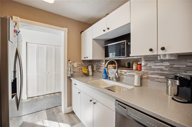 1649 W Waycross Cir, Deltona, FL 32725 - kitchen featuring stainless steel appliances, a sink, white cabinets, backsplash, and light countertops