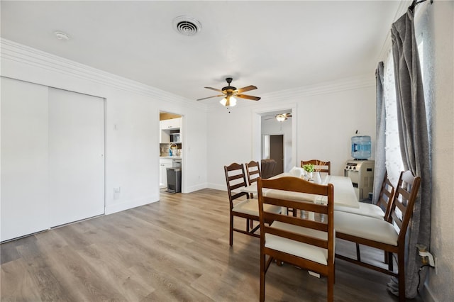 1649 W Waycross Cir, Deltona, FL 32725 - dining area featuring a ceiling fan, light wood-style flooring, crown molding, and baseboards