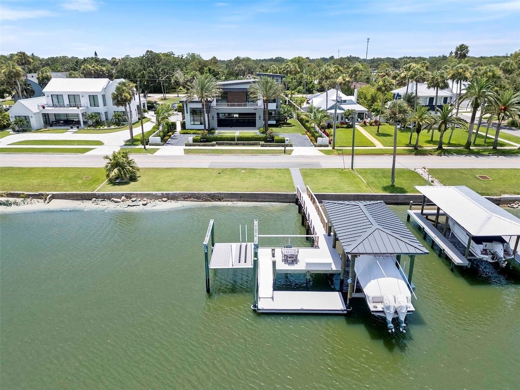 1010 S Riverside Dr, New Smyrna Beach, FL 32168 - dock featuring boat lift, a water view, a yard, and a residential view