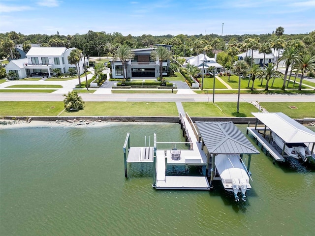 1010 S Riverside Dr, New Smyrna Beach, FL 32168 - dock featuring boat lift, a water view, a yard, and a residential view