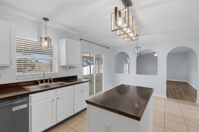 2255 Tealwood Cir, Tavares, FL 32778 - kitchen with stainless steel dishwasher, butcher block counters, a sink, and light tile patterned floors