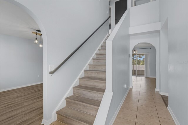 2255 Tealwood Cir, Tavares, FL 32778 - stairs with arched walkways, baseboards, and tile patterned flooring