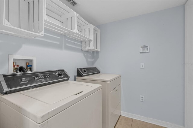 2255 Tealwood Cir, Tavares, FL 32778 - laundry room with separate washer and dryer, cabinet space, baseboards, and light tile patterned flooring
