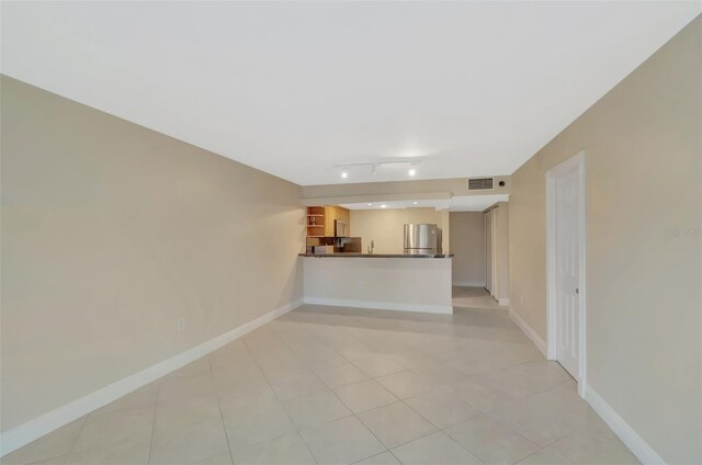 345 Ocean Dr Unit 305, Miami Beach, FL 33139 - unfurnished living room featuring baseboards and rail lighting