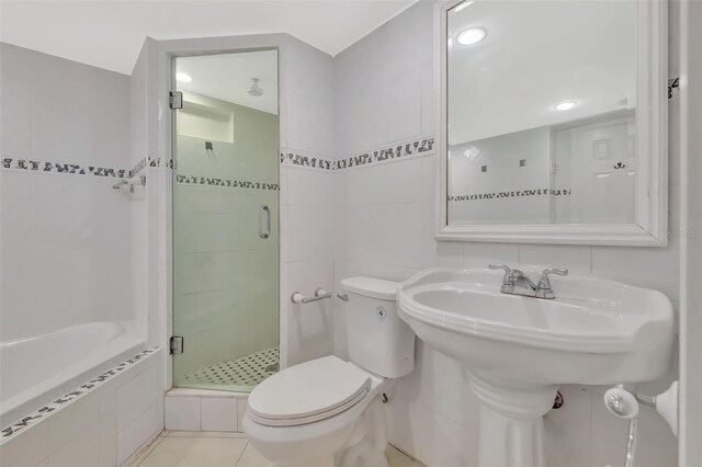 345 Ocean Dr Unit 305, Miami Beach, FL 33139 - full bath featuring a stall shower, toilet, tiled bath, tile walls, and a sink