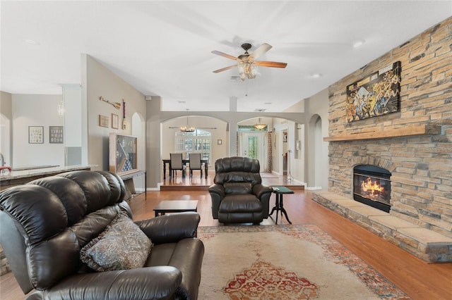 1031 Kings Hwy, Kissimmee, FL 34744 - living area featuring arched walkways, wood finished floors, ceiling fan, a stone fireplace, and a chandelier