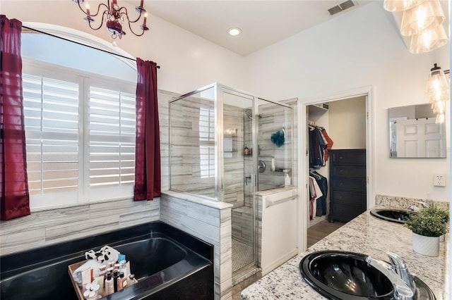 1031 Kings Hwy, Kissimmee, FL 34744 - bathroom featuring a stall shower, a garden tub, double vanity, a walk in closet, and a chandelier