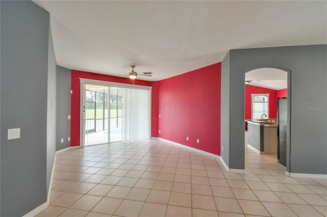 831 Corvina Dr, Davenport, FL 33897 - spare room with arched walkways, a ceiling fan, and light tile patterned floors