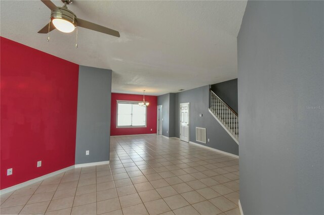 831 Corvina Dr, Davenport, FL 33897 - unfurnished living room featuring stairs, ceiling fan, light tile patterned floors, and a chandelier