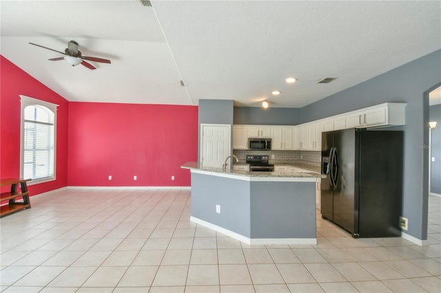 831 Corvina Dr, Davenport, FL 33897 - kitchen with black fridge, stainless steel microwave, electric range oven, a ceiling fan, and tasteful backsplash