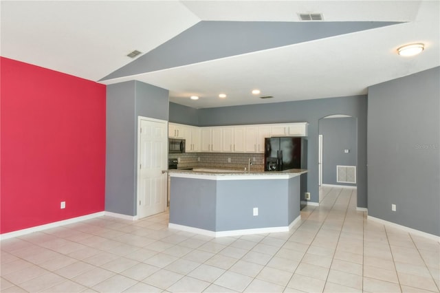 831 Corvina Dr, Davenport, FL 33897 - kitchen featuring black appliances, arched walkways, lofted ceiling, white cabinets, and backsplash