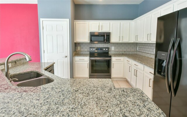 831 Corvina Dr, Davenport, FL 33897 - kitchen featuring appliances with stainless steel finishes, decorative backsplash, white cabinets, and light stone counters