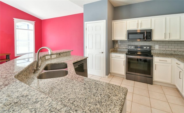831 Corvina Dr, Davenport, FL 33897 - kitchen featuring stainless steel appliances, white cabinets, backsplash, lofted ceiling, and light stone countertops