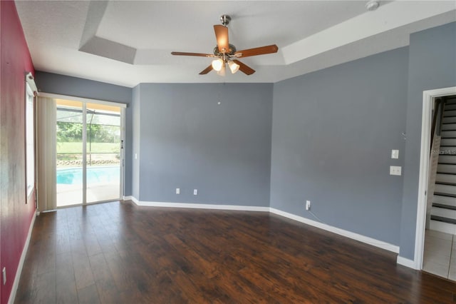 831 Corvina Dr, Davenport, FL 33897 - empty room featuring a tray ceiling, a ceiling fan, and dark wood-style floors