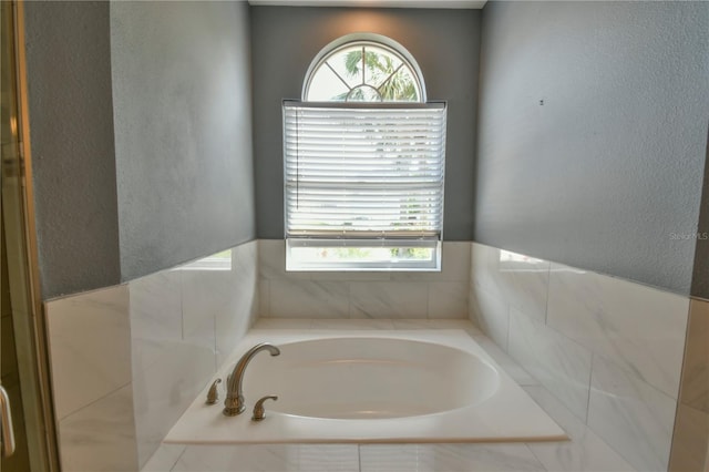 831 Corvina Dr, Davenport, FL 33897 - full bath with plenty of natural light, a garden tub, and a textured wall