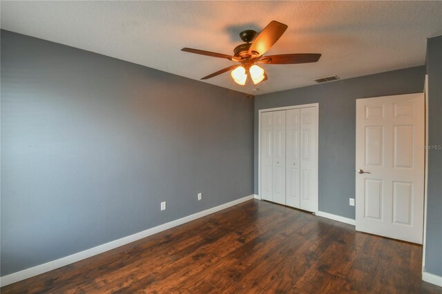 831 Corvina Dr, Davenport, FL 33897 - unfurnished bedroom featuring dark wood finished floors, a closet, and ceiling fan