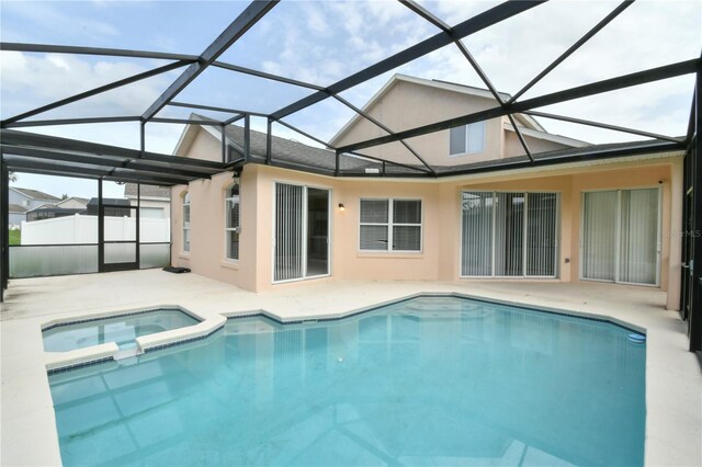 831 Corvina Dr, Davenport, FL 33897 - rear view of house with a patio, stucco siding, a pool with connected hot tub, and glass enclosure