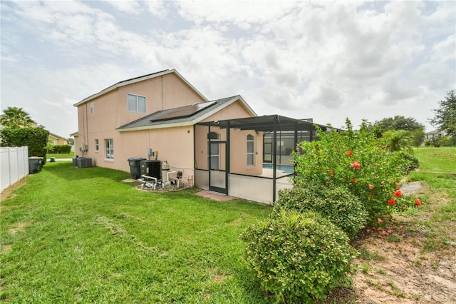 831 Corvina Dr, Davenport, FL 33897 - back of property with solar panels, a pool, stucco siding, and a lanai