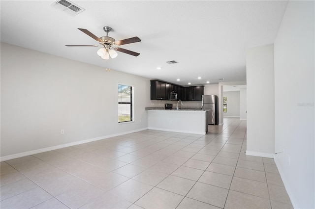 257 Fig Ct, Kissimmee, FL 34759 - unfurnished living room with a ceiling fan, light tile patterned floors, and recessed lighting