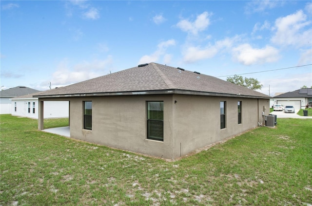 257 Fig Ct, Kissimmee, FL 34759 - rear view of property with stucco siding, roof with shingles, and a yard