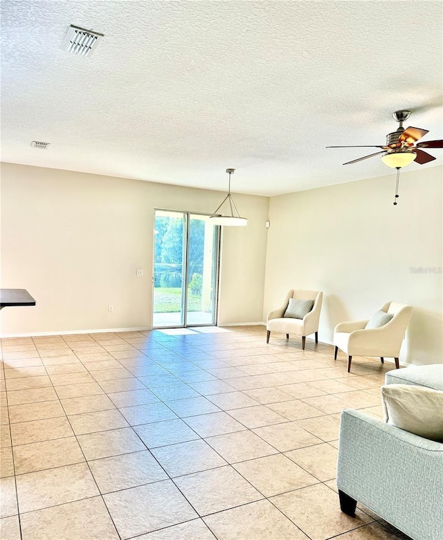 535 Aeolian Dr, New Smyrna Beach, FL 32168 - living room featuring light tile patterned floors, a textured ceiling, and a ceiling fan