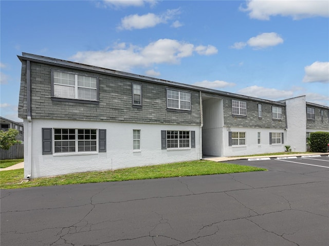 1000 S Semoran Blvd Unit 604, Winter Park, FL 32792 - view of front of house featuring stucco siding, uncovered parking, mansard roof, and roof with shingles
