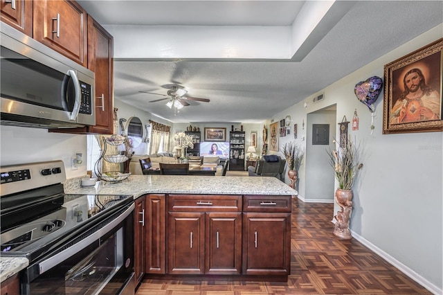 1000 S Semoran Blvd Unit 604, Winter Park, FL 32792 - kitchen featuring appliances with stainless steel finishes, a peninsula, ceiling fan, open floor plan, and baseboards