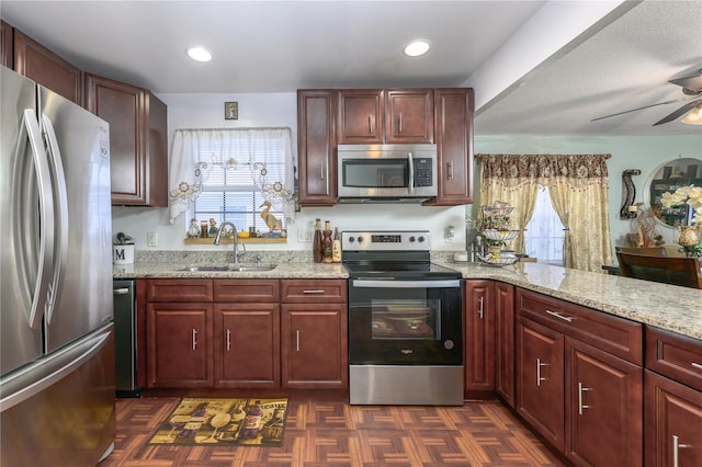 1000 S Semoran Blvd Unit 604, Winter Park, FL 32792 - kitchen featuring appliances with stainless steel finishes, a sink, a ceiling fan, and dark brown cabinets