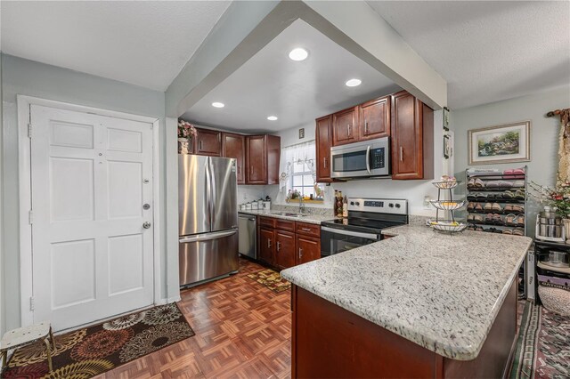 1000 S Semoran Blvd Unit 604, Winter Park, FL 32792 - kitchen with stainless steel appliances, a sink, a peninsula, recessed lighting, and light stone countertops