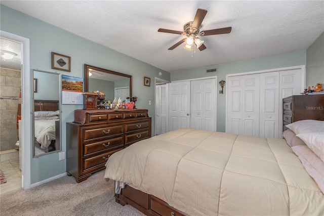 1000 S Semoran Blvd Unit 604, Winter Park, FL 32792 - bedroom with two closets, a textured ceiling, baseboards, carpet flooring, and ceiling fan