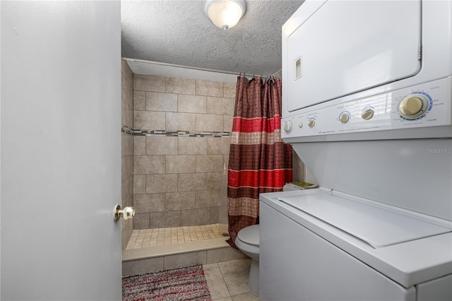 1000 S Semoran Blvd Unit 604, Winter Park, FL 32792 - bathroom featuring stacked washing machine and dryer, a stall shower, toilet, tile patterned floors, and a textured ceiling