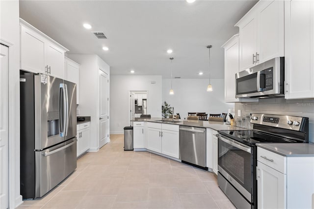 3123 Camden Way, Davenport, FL 33837 - kitchen featuring appliances with stainless steel finishes, a peninsula, white cabinetry, recessed lighting, and hanging light fixtures