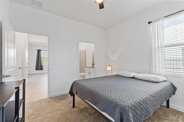3123 Camden Way, Davenport, FL 33837 - carpeted bedroom with multiple windows, baseboards, ensuite bathroom, and ceiling fan