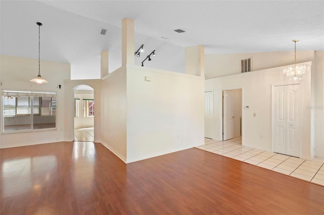 40 Hollow Pine Dr, Debary, FL 32713 - unfurnished living room with arched walkways, wood finished floors, high vaulted ceiling, and a chandelier