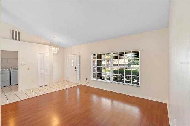 40 Hollow Pine Dr, Debary, FL 32713 - foyer entrance with washing machine and dryer, a chandelier, light wood-style flooring, and vaulted ceiling