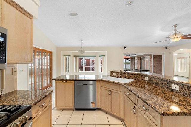 40 Hollow Pine Dr, Debary, FL 32713 - kitchen with stainless steel dishwasher, light brown cabinetry, light tile patterned floors, a ceiling fan, and dark stone countertops