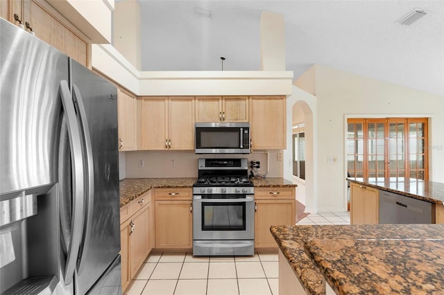 40 Hollow Pine Dr, Debary, FL 32713 - kitchen featuring appliances with stainless steel finishes, light brown cabinetry, light tile patterned floors, vaulted ceiling, and arched walkways