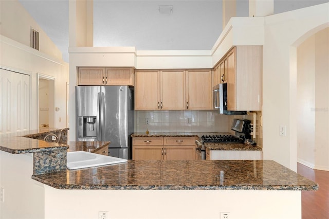 40 Hollow Pine Dr, Debary, FL 32713 - kitchen with stainless steel appliances, decorative backsplash, arched walkways, high vaulted ceiling, and dark stone countertops