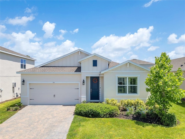744 Curly Locks Loop, Apopka, FL 32703 - view of front of home with board and batten siding, driveway, a shingled roof, an attached garage, and a front lawn