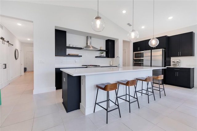 744 Curly Locks Loop, Apopka, FL 32703 - kitchen with dark cabinets, stainless steel appliances, wall chimney range hood, a kitchen breakfast bar, and lofted ceiling
