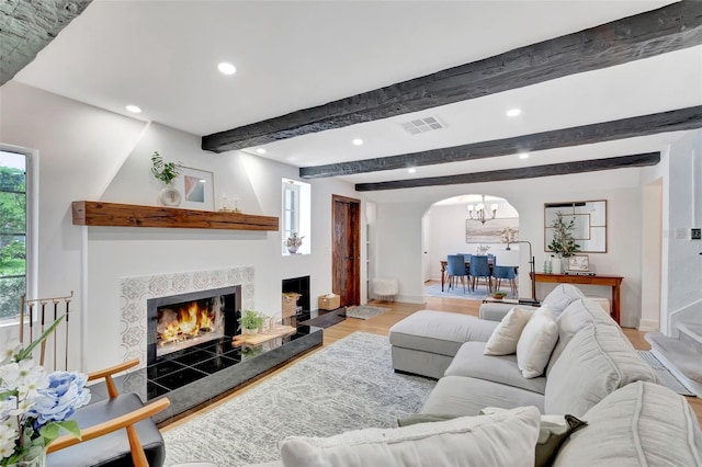 322 Cornell Dr, Lake Worth, FL 33460 - living room featuring arched walkways, recessed lighting, wood finished floors, a tiled fireplace, and baseboards
