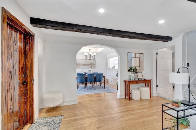 322 Cornell Dr, Lake Worth, FL 33460 - entrance foyer featuring arched walkways, light wood-type flooring, beam ceiling, baseboards, and a chandelier