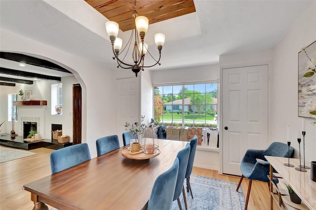 322 Cornell Dr, Lake Worth, FL 33460 - dining room with arched walkways, light wood finished floors, a chandelier, and a fireplace