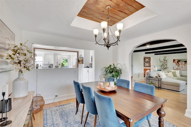 322 Cornell Dr, Lake Worth, FL 33460 - dining room featuring arched walkways, a chandelier, light wood-style flooring, a raised ceiling, and wood ceiling