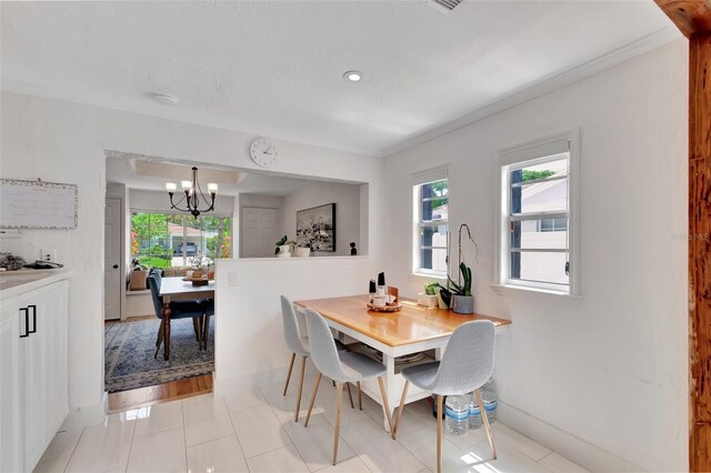 322 Cornell Dr, Lake Worth, FL 33460 - dining space featuring a chandelier, healthy amount of natural light, baseboards, light tile patterned floors, and crown molding